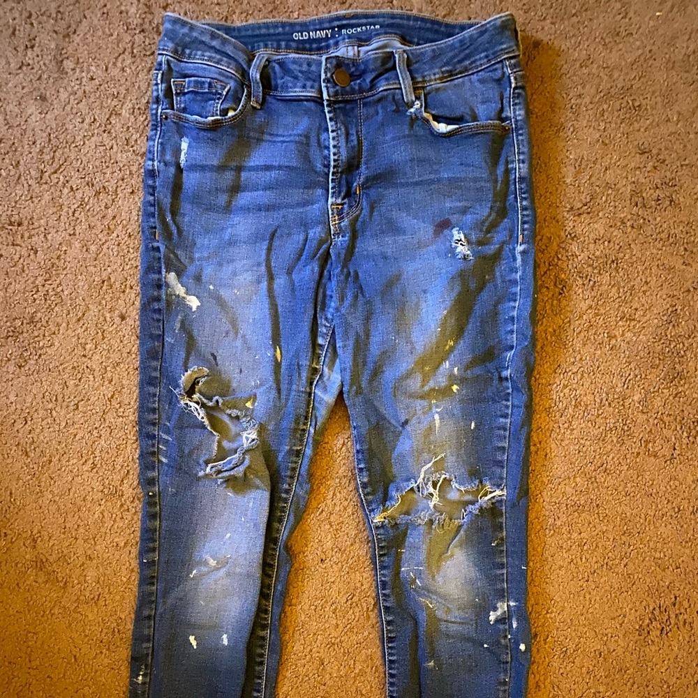 Blue ripped jeans with white paint splatters